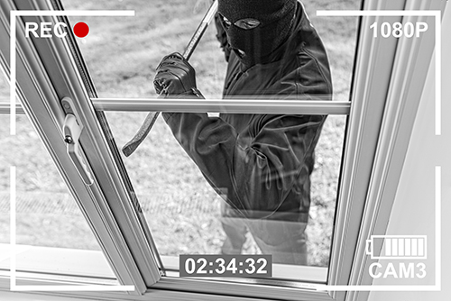 CCTV view of burglar breaking in to home through window Ein Dieb versucht einzubrechen. Schützen Sie sich mit S&P-